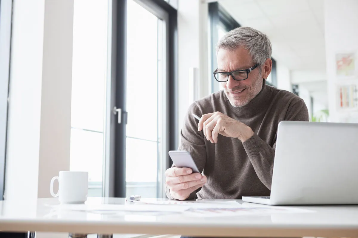 Hombre con su computadora portátil y su teléfono