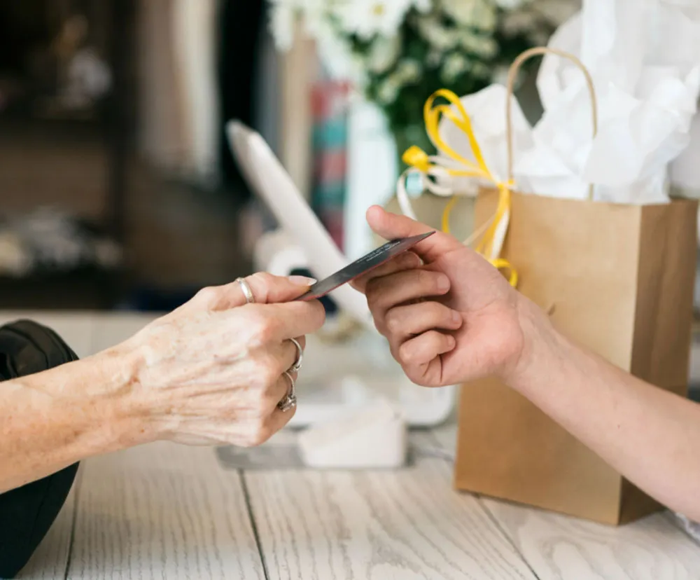 Seseorang menyerahkan kartu pembayaran ke orang lainnya