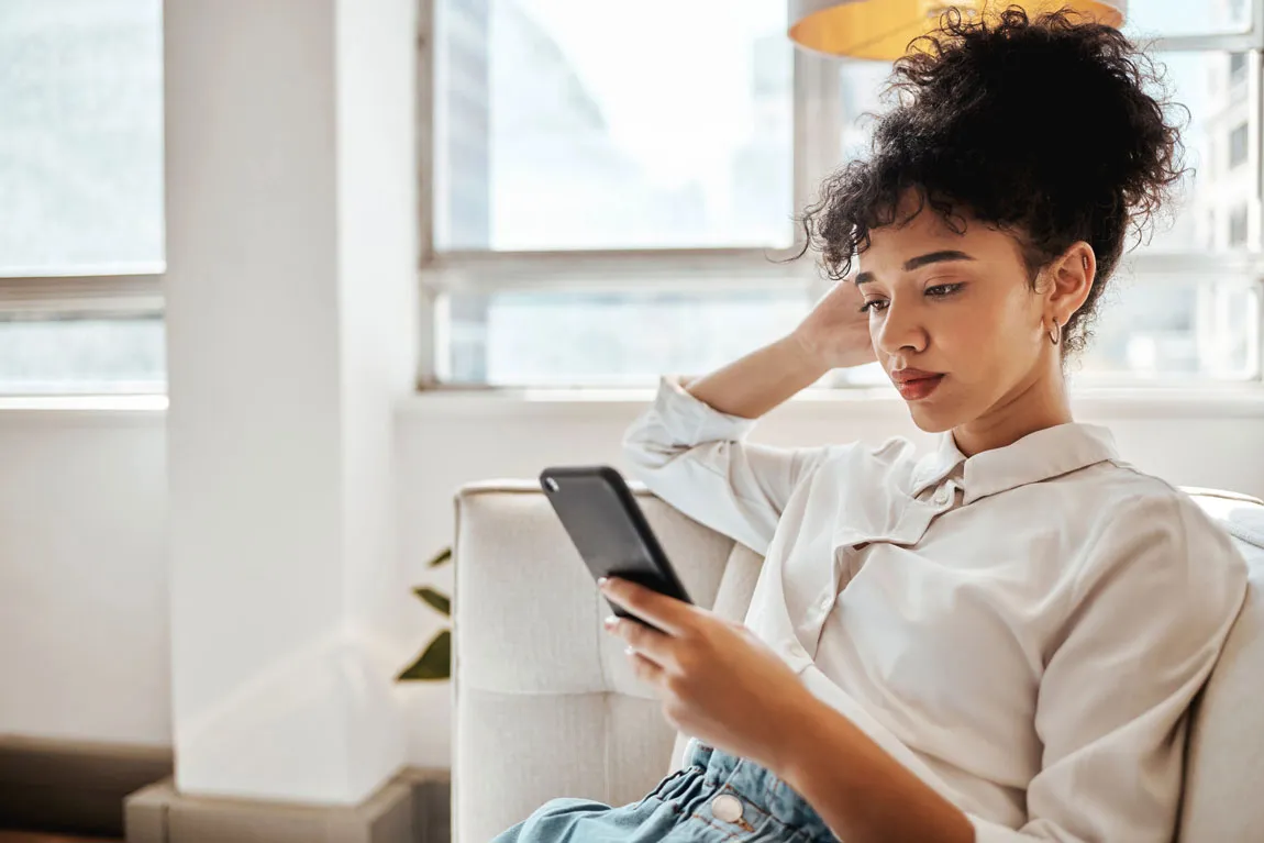 A woman looking at a text conversation