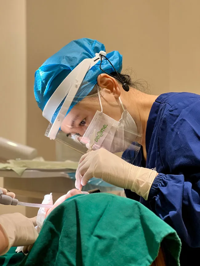 Une dentiste concentrée effectuant une opération chirurgicale