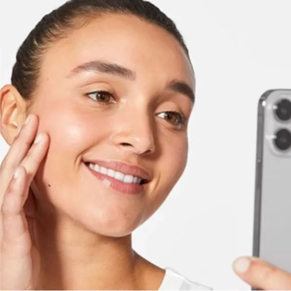 Mujer mirando su reflejo en un teléfono