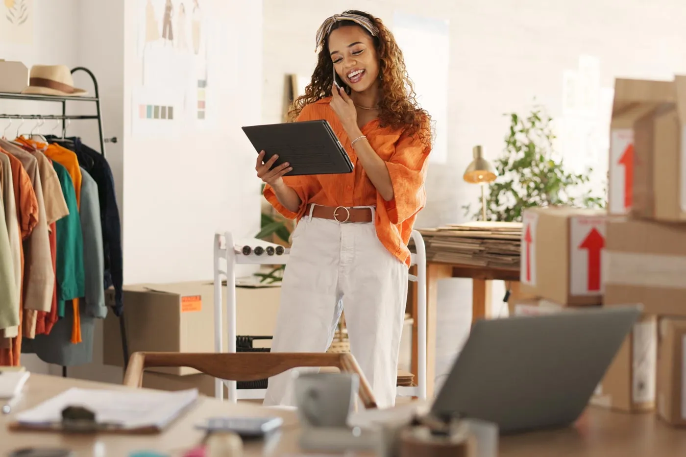 Une femme d’affaires au téléphone regarde un rapport dans son magasin.